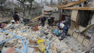 Villagers clear the rubble after Russia's night rocket attack ruined private houses in a village.