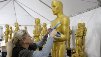 Antje Menikheim, lead scenic painter for Sunday's 95th Academy Awards, readies an Oscar statue for the event