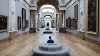 Someone sits on a bench inside a museum