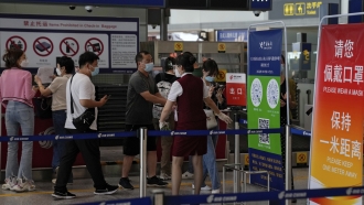 Travelers declare their health information after checking in at the Beijing Capital International Airport