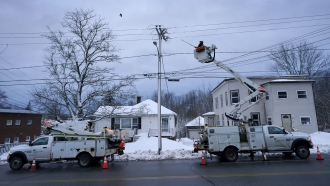 Central Maine Power Co. lineman works to restore electricity.