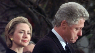 Hillary Rodham Clinton watches President Clinton give a speech.
