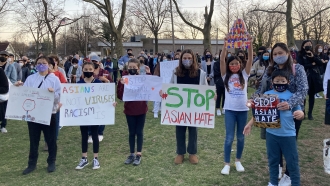 Children holding "stop Asian hate" posters.