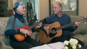 Lynda Shannon Bluestein, left, jams with her husband Paul in the living room of their home
