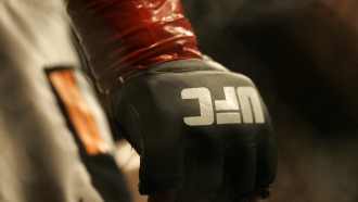 Closeup of a glove and the UFC logo.