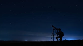 Person using a telescope at night.