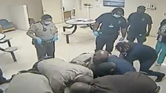 An image from a video shows deputies on top of man in custody.