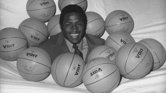 New York Knicks NBA player Willis Reed is surrounded by basketballs.