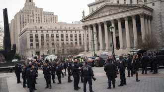 NY police officers wait for instructions around the courthouse ahead of former President Trump's anticipated indictment.
