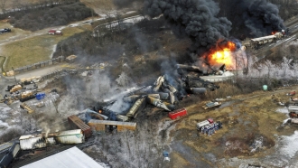 Aerial photo shows portions of a Norfolk Southern freight train on fire.