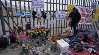 An altar with candles and photos covers the fence outside the Mexican immigration detention center.