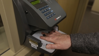 A man uses palm scanner technology.