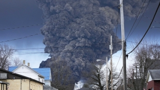 Black plume of smokes rises over East Palestine, Ohio, after a toxic train derailment.