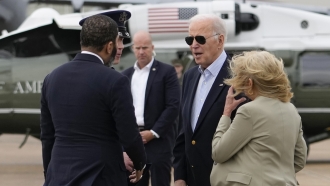 President Joe Biden and first lady Jill Biden greet a person.