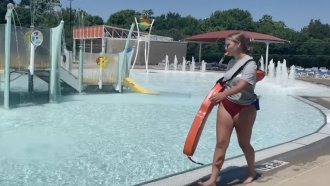 Lifeguard walks along swimming pool