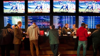 Gamblers place bets in sports betting area.