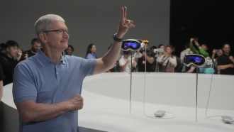 Apple CEO Tim Cook poses for photos in front of a pair of the company's new Apple Vision Pro.