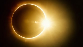 Annular solar eclipse shows the sun peeking around the disc of the moon.