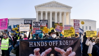Demonstrator holds a sign that reads "Hands Off Roe!!!"