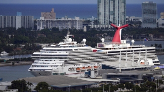The Carnival Conquest cruise ship sits docked at a port.