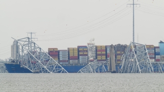A container ship rests against the wreckage of the Francis Scott Key Bridge