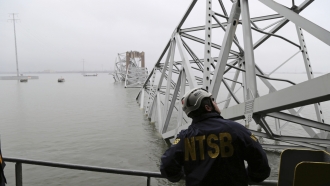 A NTSB investigator is seen on the cargo vessel Dali, which struck and collapsed the Francis Scott Key Bridge
