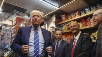 Former president Donald Trump, left, gestures while visiting a bodega.