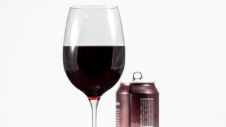 Aluminum can of California Pinot Noir behind a full glass of red wine
