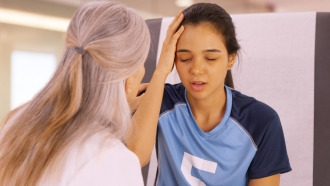 Soccer player holding her head after an injury visits a doctor's office.