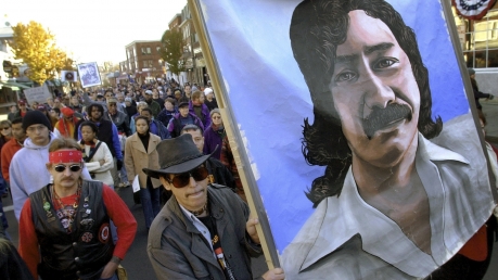 People carry a painting of jailed American Indian Leonard Peltier during a march.