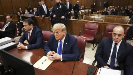 Former president Donald Trump, center, awaits the start of proceedings at Manhattan criminal court.
