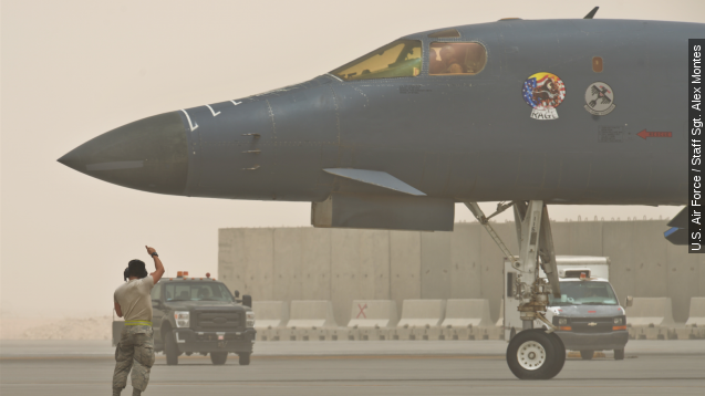 An airman from the 340th Expeditionary Aircraft Maintenance Unit directs a B-1 Lancer to the runway in Qatar.