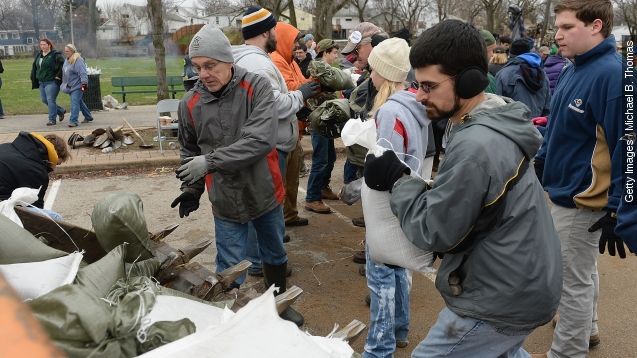 Volunteers create and load sandbags on the banks of the River Des Peres on December 29, 2015 in St. Louis, Missouri.