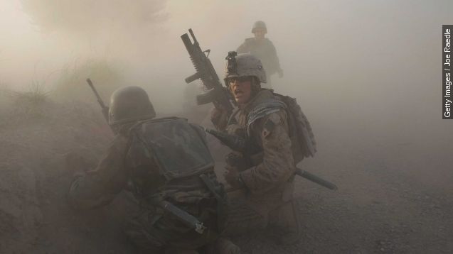 A U.S. Marine with the 2nd Marine Expeditionary Brigade, RCT 2nd Battalion 8th Marines Echo Co. along with an Afghan soldier react as dust blankets the area after an IED exploded while they were under enemy fire on July 17, 2009 in Mian Poshteh, Afghanistan.