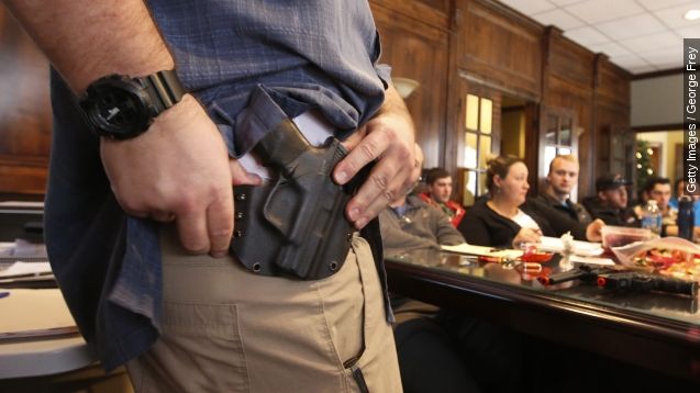 A man adjusts a gun in a belt holster.