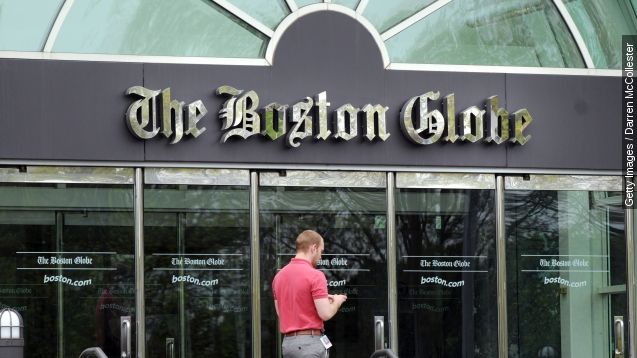 A man walks by the front of The Boston Globe headquarters May 4, 2009 in Dorchester, Massachusetts.