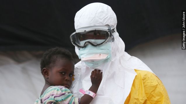 A Liberian health worker in protective clothing holds a child suspected of having Ebola.