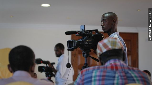 A Somalian journalist operates a camera.
