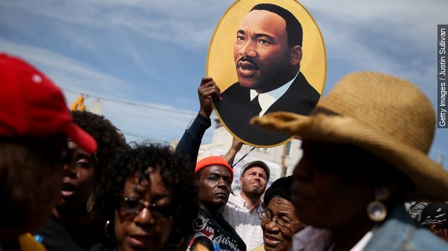 A marcher holds a picture of Dr. Martin Luther King Jr. before walking across the Edmund Pettus Bridge during the 50th anniversary commemoration of the Selma to Montgomery civil rights march on March 8, 2015 in Selma, Alabama. Tens of thousands of people gathered in Selma to commemorate the 50th anniversary of the famed civil rights march from Selma to Montgomery that resulted in a violent confrontation with Selma police and State Troopers on the Edmund Pettus Bridge on March 7, 1965.
