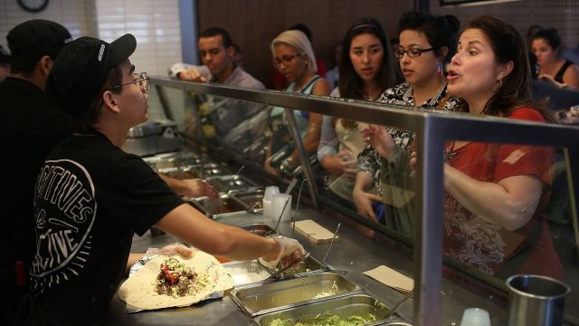 Chipotle restaurant workers fill orders for customers on the day that the company announced it will only use non-GMO ingredients in its food on April 27, 2015 in Miami, Florida.
