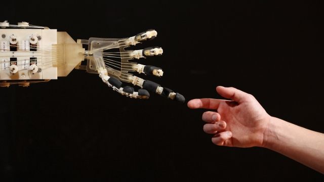 A robotic hand interacts with a human.