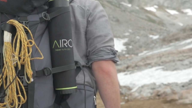 A hiker is seen carrying a Fontus Airo water bottle strapped to his backpack.