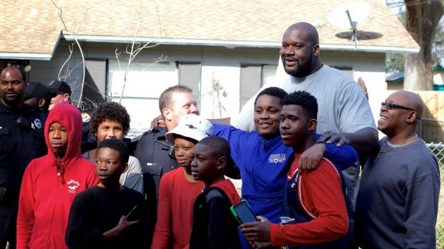 Shaquille O'Neal stands with kids and police officers from Gainesville, Florida, after a pickup basketball game.