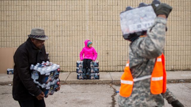 People in Flint, Michigan take cases of water home.