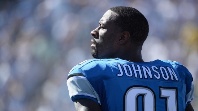 Calvin Johnson stands on the sidelines.