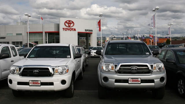 Trucks sit outside of a Toyota dealership.