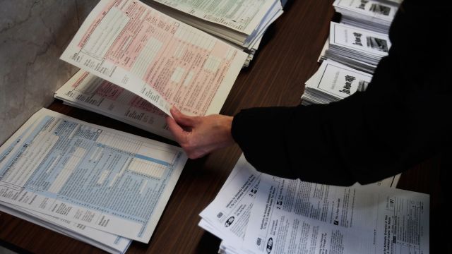 A woman picks up a tax form.