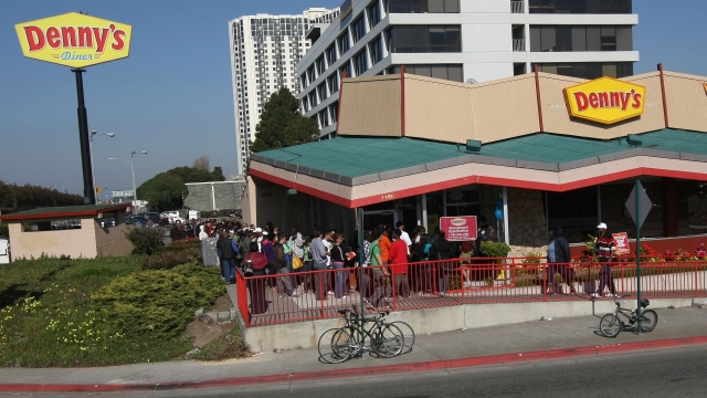 Customers wait outside of a Denny's.