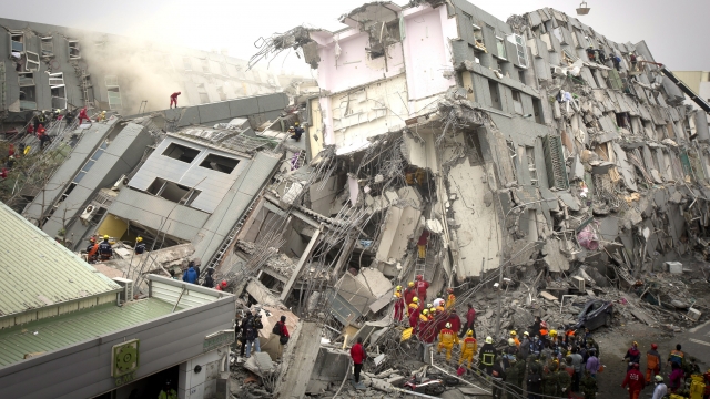Rescue personnel search for survivors at the site of a buildling that collapsed during an earthquake in Taiwan.