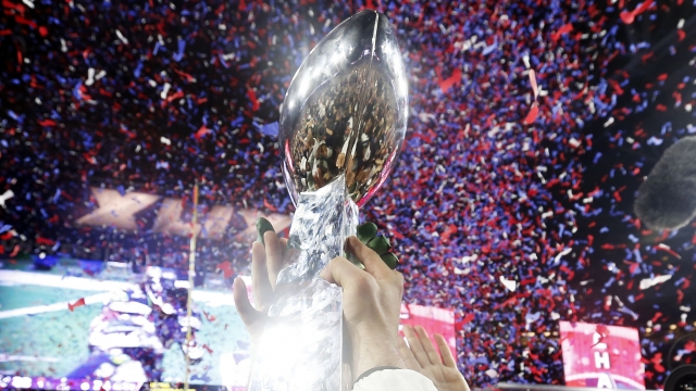 Members of the New England Patriots celebrate with the Vince Lombardi Trophy after defeating the Seattle Seahawks 28-24 in Super Bowl XLIX at University of Phoenix Stadium on February 1, 2015 in Glendale, Arizona.